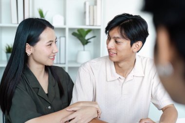 Çağdaş bir ev ortamında finans danışmanıyla finansal planlama tartışması yapan genç bir çift..