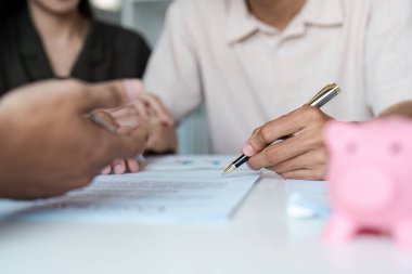 Tasarruf, bankacılık ve yatırım planlama konularında bir finans danışmanıyla birkaç görüşme. Yakın plan çekimler, belgeler ve kumbara..