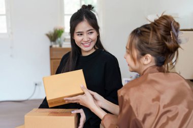 Neşeli bir lezbiyen çift yeni evlerinde kutuları açıyor, birlikte yeni bir sayfa açtıklarında gülümsemelerini ve heyecanlarını paylaşıyorlar..