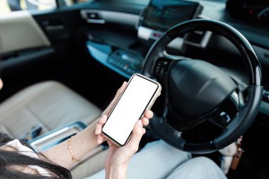 Araba kullanırken cep telefonu kullanan bir kadının yüksek kalite maket görüntüsü, uygulama veya web sitesi tasarım sunumları için ideal.