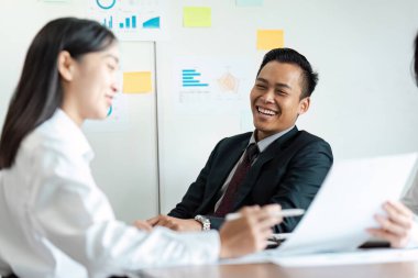 Bir grup iş adamı, modern ofis ortamında grafikleri ve grafikleri tartışarak verimli bir toplantı yaptılar..