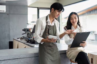 Modern bir kahve dükkanında iş birliği yapan ve girişimleri için fikir alışverişinde bulunan iki genç iş adamı..