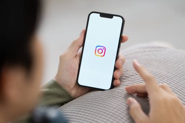CHIANG MAI, THAILAND - 11 Eylül 2024: Instagram uygulamasının logosu ile el ele tutuşan kadın. Instagram en büyük ve en popüler sosyal ağdır..