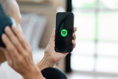 CHIANG MAI, THAILAND - 19 Temmuz 2024: Ekranda Spotify logosu olan yepyeni bir Apple iPhone 13 Pro tutan kişi. Spotify popüler bir ticari müzik yayın servisidir..