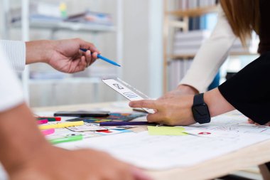 UX UI tasarımı üzerinde çalışan, kablolar ve prototipleri, takım çalışmalarını ve modern tasarım süreçlerini tartışan yaratıcı bir ekibin yakın çekimi..