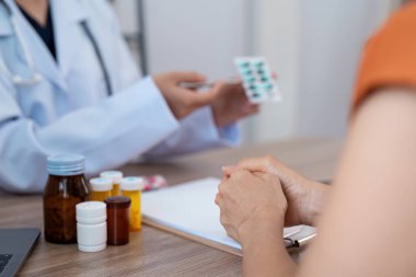 Bir doktorun hastaya danışmanlık yapması, ilaç yazması, profesyonel bir sağlık ortamını sergilemesi..