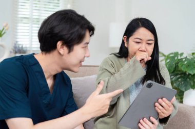 Modern bir klinik ortamında dijital tablet kullanan bir hastaya danışmanlık yapmak, teknolojiyi ve hasta bakımını vurgulamak.