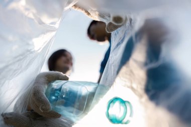Plastik şişe toplamak, çevre bilincini ve kamu hizmetini desteklemek için birlikte çalışan bir gönüllü..
