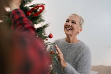 Kadınlar Noel için evlerinde dekore ederler. Aile kutlaması ve evde mutlu yıllar..