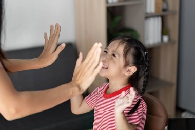 Öğrenme etkinliğine aktif olarak katılan mutlu bir çocuk, bir sınıf ortamında eğitim ve etkileşimin neşesini sergiliyor..
