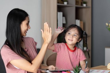 Mutlu bir çocuk ebeveyniyle öğreniyor, eğitim ve başarının sevincini besleyen bir evde gösteriyor..