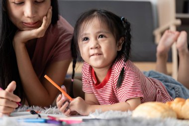 Eğitimsel materyallerle çevrili, evde öğrenen küçük bir çocuk, yaratıcılığı ve bilgiyi rahat bir ortamda teşvik ediyor..
