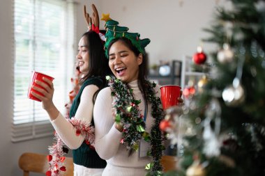 Noel 'i süslerle kutlayan iki arkadaş, şenlikli aksesuarlar takan ve Noel ruhunun tadını çıkaran iki arkadaş..