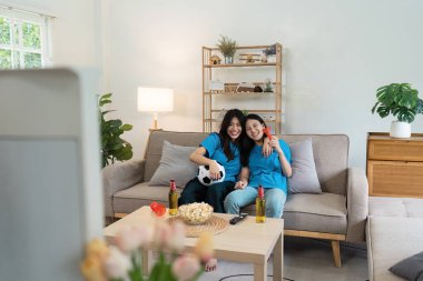 İki arkadaş evde maç izlerken tezahürat yapıyor. Etrafı abur cubur ve içkilerle çevrili. Heyecan ve coşku dolu..