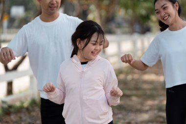 Parkta egzersiz yapan neşeli bir aile. Mutluluk ve sağlıklı yaşam sergiliyor..