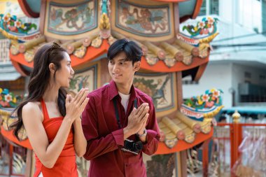 Genç bir çift, Çin Yeni Yılı 'nı neşeli bir şekilde kutluyor. Gelenekleri, şenlikli dekorlarla dolu canlı bir şehir ortamında kucaklıyorlar..