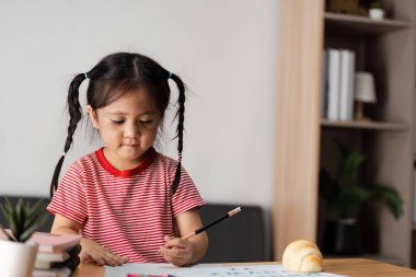 Bir ebeveyn ve çocuk birlikte öğrenme aktivitesinden zevk alıyor, eğitimi, yaratıcılığı ve aile bağlarını ön plana çıkarıyor.