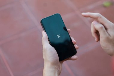 Chiang Mai, Tayland - 25 Haziran 2024: iPhone 13 Pro 'da X yeni twitter uygulaması kullanan adam. iPhone 13 ekranındaki yeni bir Twitter X uygulama logosunun yakın plan resmi.