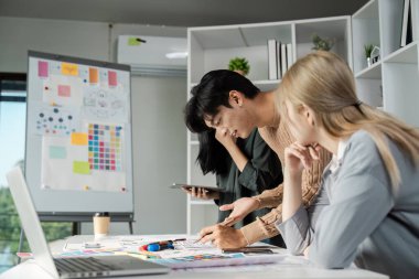 UX UI tasarım projelerinde birlikte çalışan profesyoneller, bir iş ortamında takım çalışması ve yenilik sergiliyorlar.