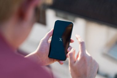 Chiang Mai, Tayland - 25 Haziran 2024: iPhone 13 Pro 'da X yeni twitter uygulaması kullanan adam. iPhone 13 ekranındaki yeni bir Twitter X uygulama logosunun yakın plan resmi.