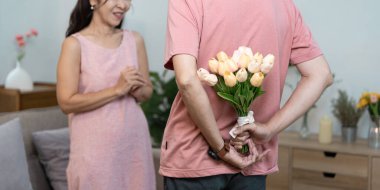 Bir adam partnerine bir buket lale ile sürpriz yapar, aşkı ve sevgiyi simgeler, Sevgililer Günü kutlamaları için mükemmeldir..