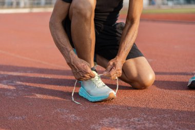 Yaşlılar, spor ayakkabılarını piste bağlayıp, son sınıflarda aktif yaşam ve refahı sembolize ediyor..