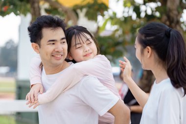 Gülümseyen bir baba, kızını sırtında taşımaktan zevk alır, anne iç açıcı bir sohbete girişir, neşeli bir açık havada ailenin birlikteliğini ön plana çıkarır..