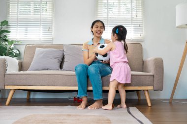 Bebekken neşeli bir etkileşim annesini bir futbol topuyla şaşırtır. Oturma odalarında eğlenceli ve eğlenceli bir atmosfer yakalar..