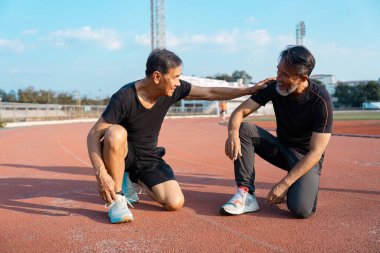 İki destekleyici yaşlı adam bir pistte çalıştıktan sonra cesaret verici bir anı paylaşıyor, aktif yaşlanma sürecinde arkadaşlık ve sağlığın önemini gösteriyor..