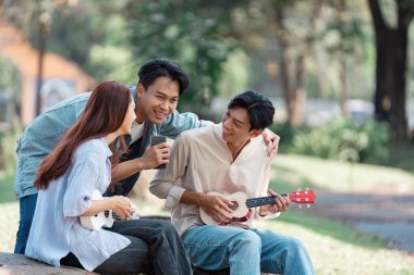 Bir grup arkadaş, arkadaşlığı ve yaratıcılığı kutlayan, canlı bir açık havada, ukulele çalıp birlikte şarkı söyleyen neşeli anları paylaşıyor..