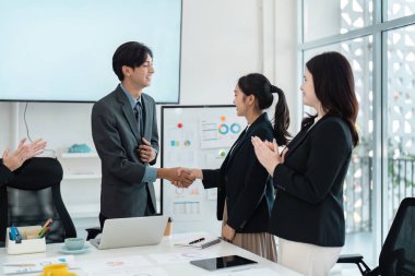 İş adamları başarılı bir ortaklığı bir şirket toplantısında el sıkışma, takım çalışması ve işbirliği ile kutluyorlar..