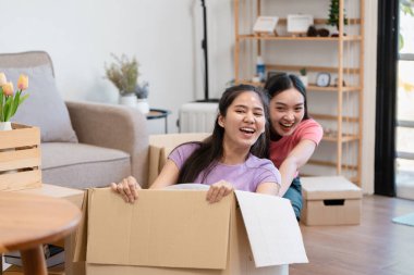 Neşeli, çeşitli bir çift, yeni evlerini açarken birlikte gülerek kutuları taşımaktan zevk alır..