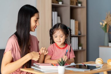 Neşeli bir anne kızının yemek masasını boyayarak ve çizerek yaratıcılığını keşfetmesine yardım eder..
