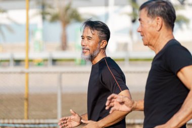 İki son sınıf öğrencisi parkta koşuyor, fiziksel aktivite ve arkadaşlık yoluyla sağlık ve sağlık hizmetlerini destekliyorlar..