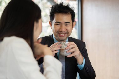 İki iş adamı bir toplantı sırasında kahve molası verip rahat ve dost canlısı bir ortam yaratıyorlar..