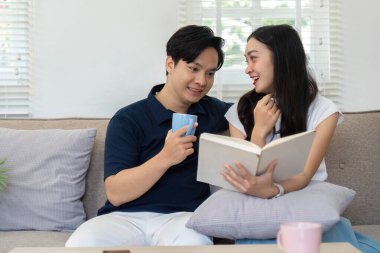 Bir çift kanepede oturur, kitap paylaşır ve sıcak içeceklerle birbirlerine eşlik ederler..