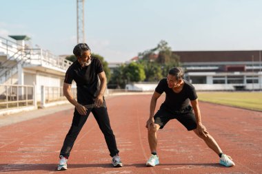 Açık havada egzersiz yapan iki kıdemli adam aktif bir yaşam tarzında sağlık ve sağlığı destekliyor..