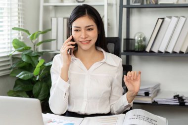 Finansal danışman, notlarını düzenli tutarken pazar analizi ve stratejilerini tartışmak için önemli aramalar yapıyor..