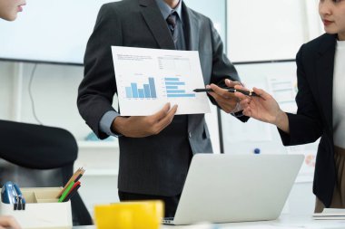 Güvenilir bir iş adamı, önemli bulguları ve stratejileri vurgulayarak iş arkadaşlarına veri içgörüleri sunar.