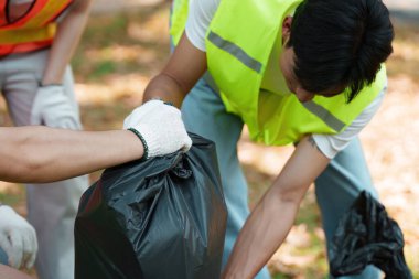 Toplumu temizlemek, atık toplamak ve mahallelerinde çevresel sürdürülebilirliği desteklemek için işbirliği yapan çeşitli bir grup gönüllü..