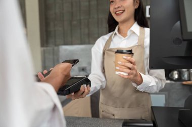 Dost canlısı bir barista, sürdürülebilir bir kafede müşterileriyle etkileşime geçer ve çevre dostu seçenekler sunar. Bu resim, müşteri hizmetleri ve yeşil işletmelerdeki sürdürülebilir uygulamaları vurgular.