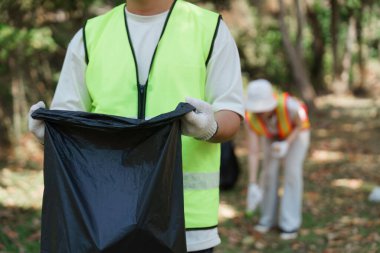 Hevesli bir gönüllü, parktaki çöpleri temizleyerek, toplum sağlığına ve korunmasına katkıda bulunarak sürdürülebilir bir geleceğe olan bağlılığını gösteriyor..