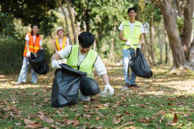 Toplum hizmeti ve çevre sorumluluğunu vurgulamak için parkta çöp toplamak için birlikte çalışan bireylerden oluşan özel bir ekip..