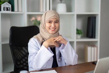 Klinikte çalışan bir sağlık uzmanı sıcak ve ulaşılabilirlik yayar ve hastaları endişelerini ve ihtiyaçlarını tartışmaya davet eder..