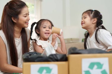 Mutlu bir aile, çocukluk öğreniminde sürdürülebilirliğin önemini vurgulayarak, çevre dostu el sanatları yoluyla bir anlık bağlantının keyfini çıkarır..