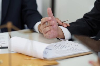 Bir grup avukat, bir sözleşmedeki kritik noktaları tartışıyor, işbirliğini ve ilgili yasaları tam olarak anlamayı vurguluyor.