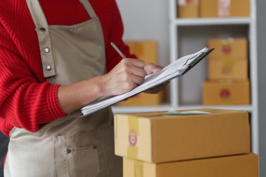 Girişimci sevkiyat detaylarını yakalar, müşteri memnuniyetini ve zamanında teslimatı sağlamak için e-ticaret işindeki organizasyonu vurgular..