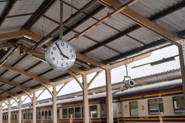 Tren istasyonundaki saat geçen zamanı simgeliyor ve yolcuların yolculuklarını beklerken beklentilerini artırıyor. Varlığı seyahat deneyimine bir aciliyet katıyor..