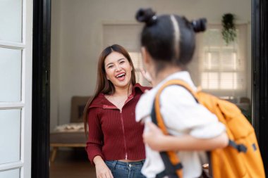 Bir anne kızını kapısının önünde sevinçle karşılar. Okuldaki ilk gününde onu uğurlamak için heyecanlanır. Sevgi ve cesaret gösterir..