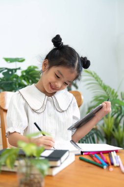 Neşeli genç bir kız, yaratıcılığını yazarak ifade eder. Öğrenmeye karşı olumlu bir tutum sergiler..